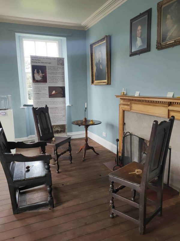 What would have been the Parlour room at Epworth Old Rectory featuring chairs set around a fireplace.