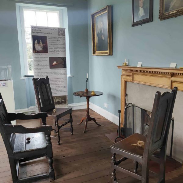 What would have been the Parlour room at Epworth Old Rectory featuring chairs set around a fireplace.